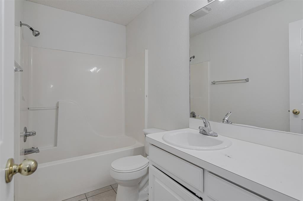 606 McAnear Street Cleburne, TX 76033 - Photo 15 of 19 a bathroom with a sink toilet and shower