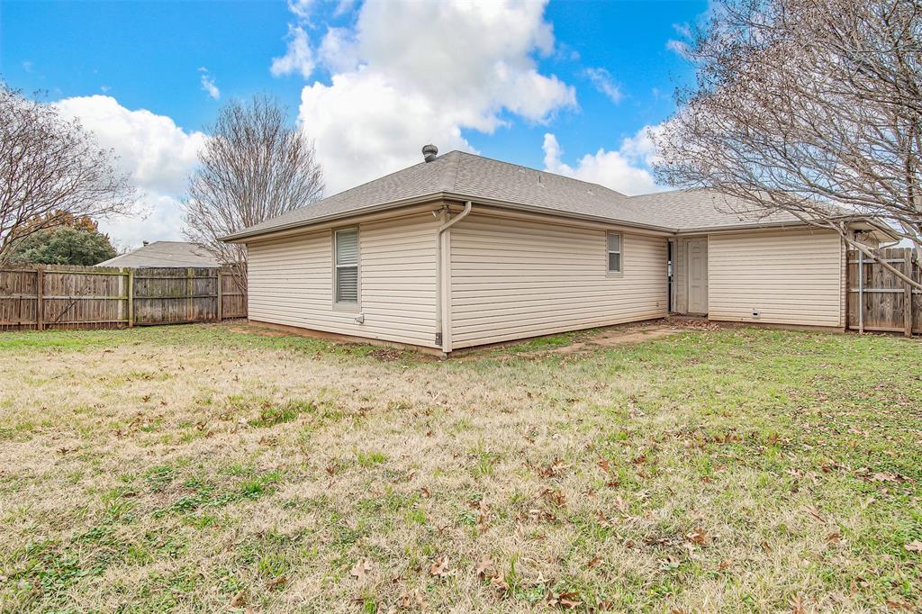 606 McAnear Street Cleburne, TX 76033 - Photo 18 of 19 a view of a house with a backyard