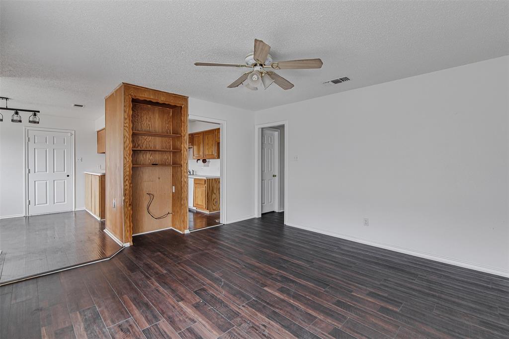 606 McAnear Street Cleburne, TX 76033 - Photo 4 of 19 a view of empty room with wooden floor and ceiling fan
