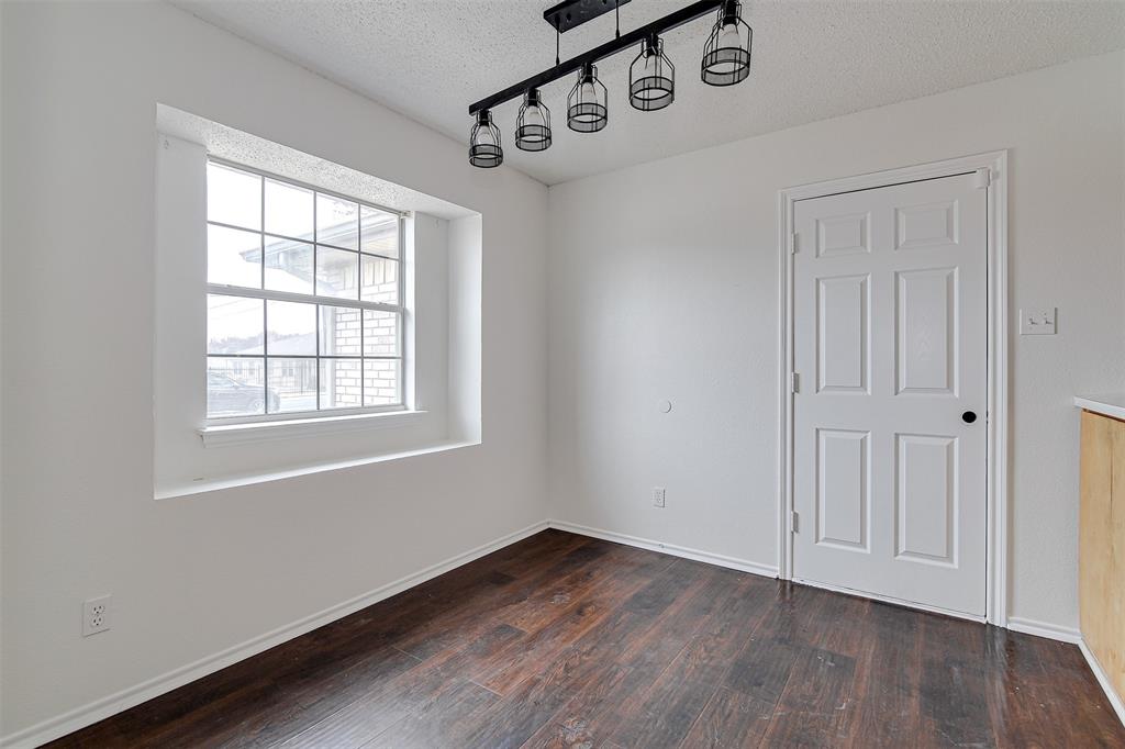 606 McAnear Street Cleburne, TX 76033 - Photo 9 of 19 an empty room with wooden floor and windows