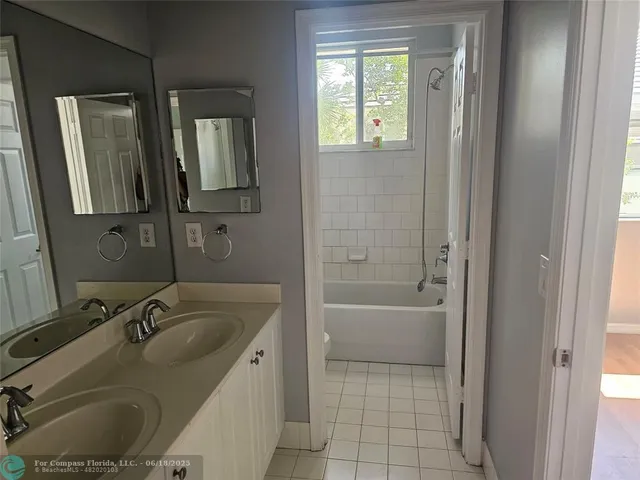 a bathroom with a granite countertop sink a mirror and a bathtub