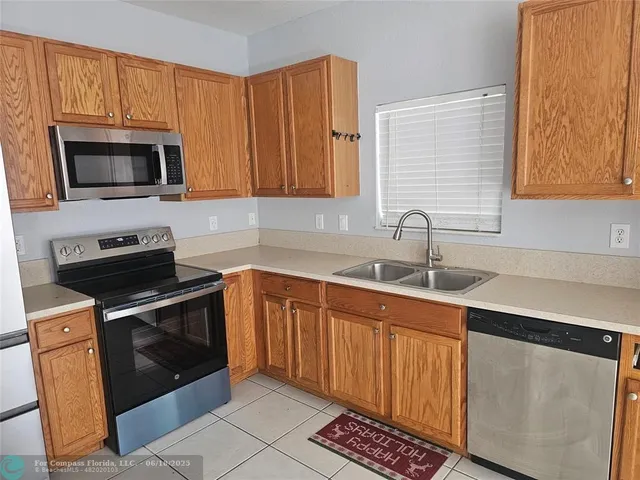 a kitchen with stainless steel appliances granite countertop a sink stove and microwave