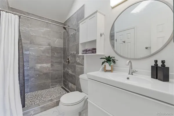 a bathroom with a sink a toilet and a mirror