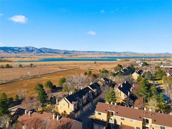 an aerial view of ocean and residential houses with outdoor space