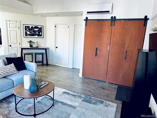 a living room with furniture and a wooden floor