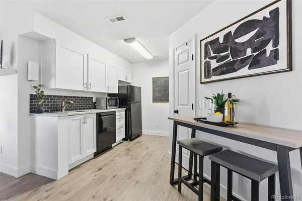 a kitchen with a refrigerator and white cabinets