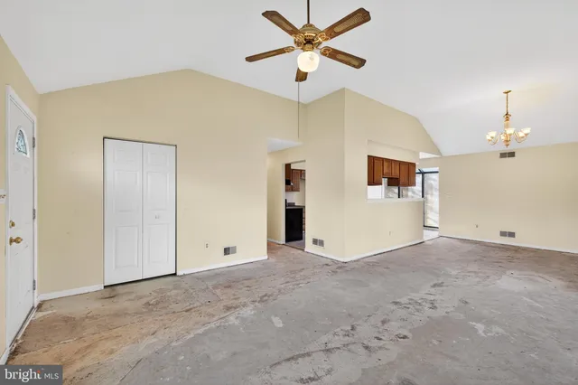 an empty room with a ceiling fan and a window