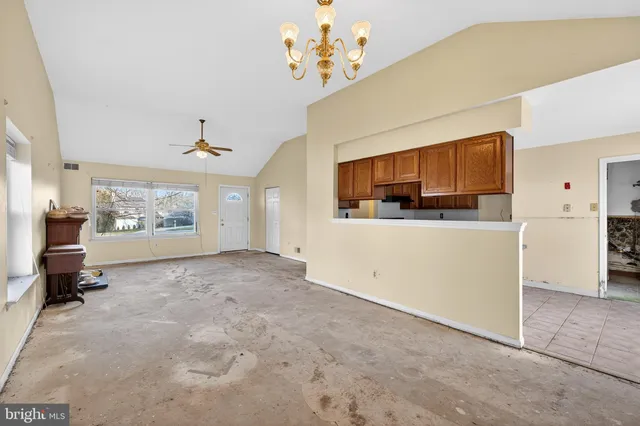 a view of a livingroom with kitchen furniture and a ceiling fan