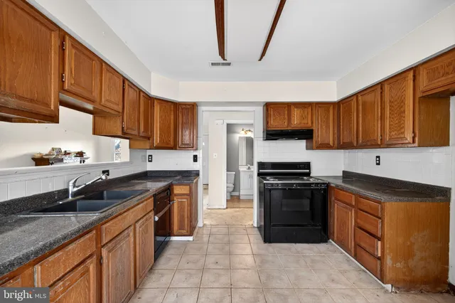 a kitchen with stainless steel appliances granite countertop wooden cabinets a stove top oven a sink and dishwasher