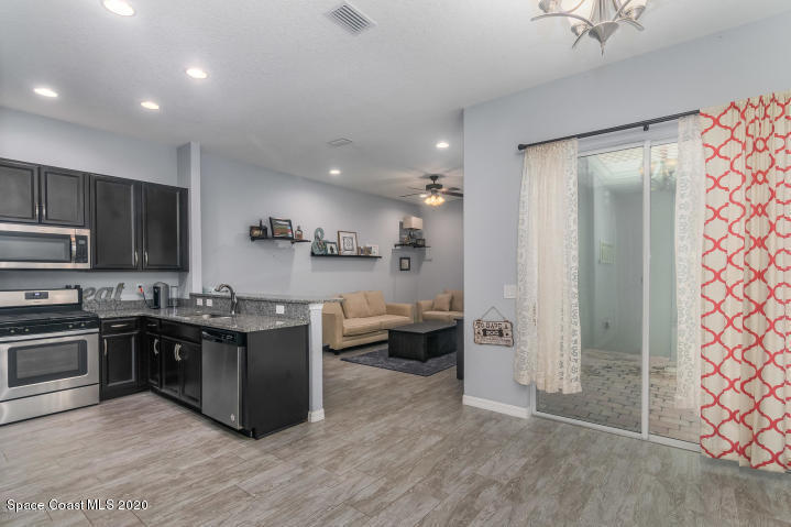 3465 Sedge Drive Rockledge, FL 32955 - Photo 12 of 12 a kitchen with stainless steel appliances kitchen island granite countertop a refrigerator and a stove top oven