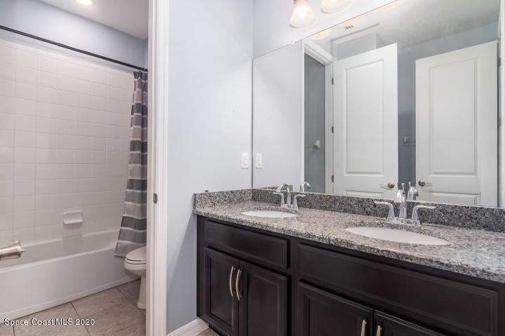3465 Sedge Drive Rockledge, FL 32955 - Photo 8 of 12 a bathroom with a granite countertop sink a toilet and bathtub