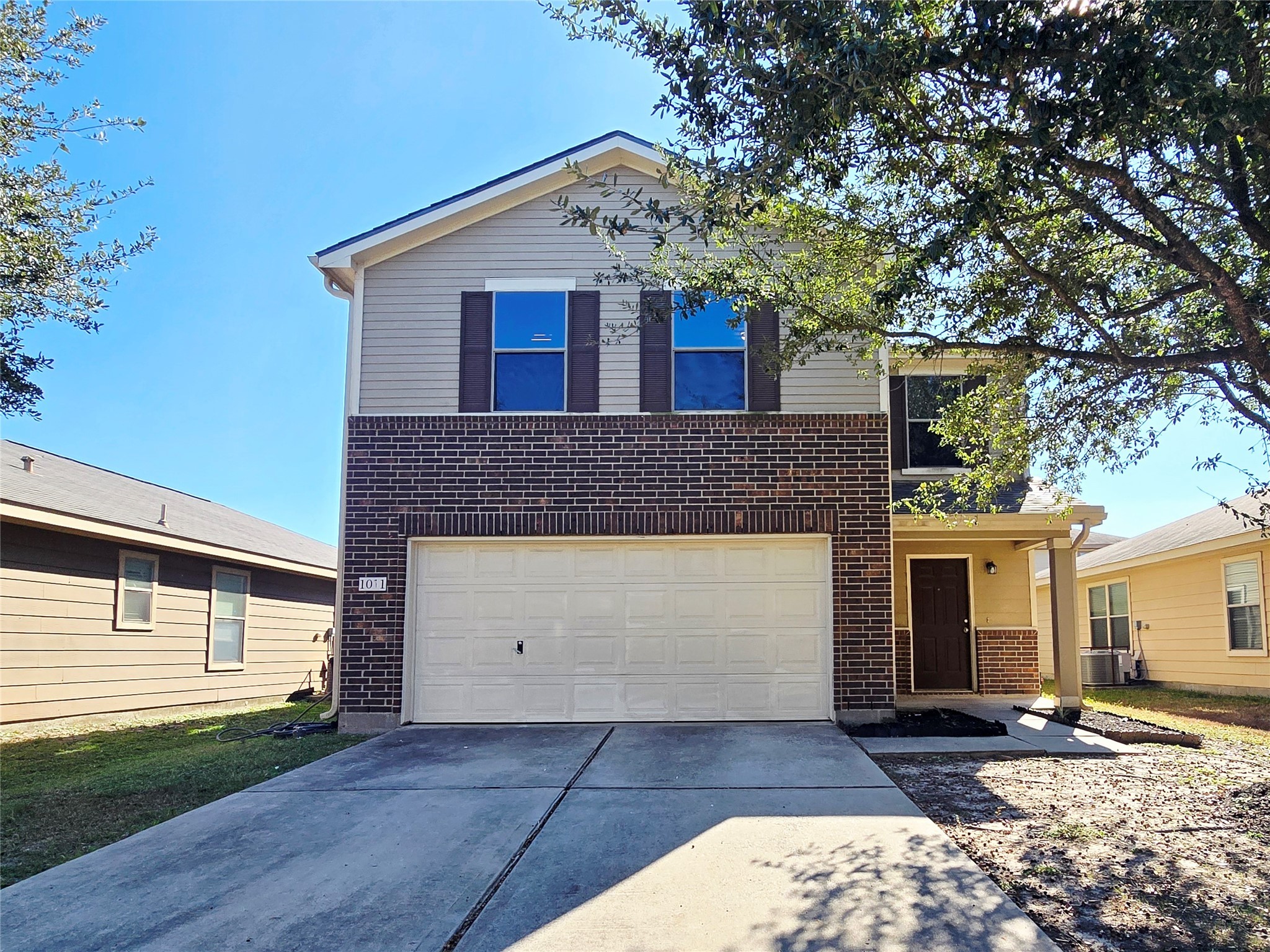 1011 Larks Trace Lane Houston, TX 77090 - Photo 1 of 26 a front view of a house with a yard and garage