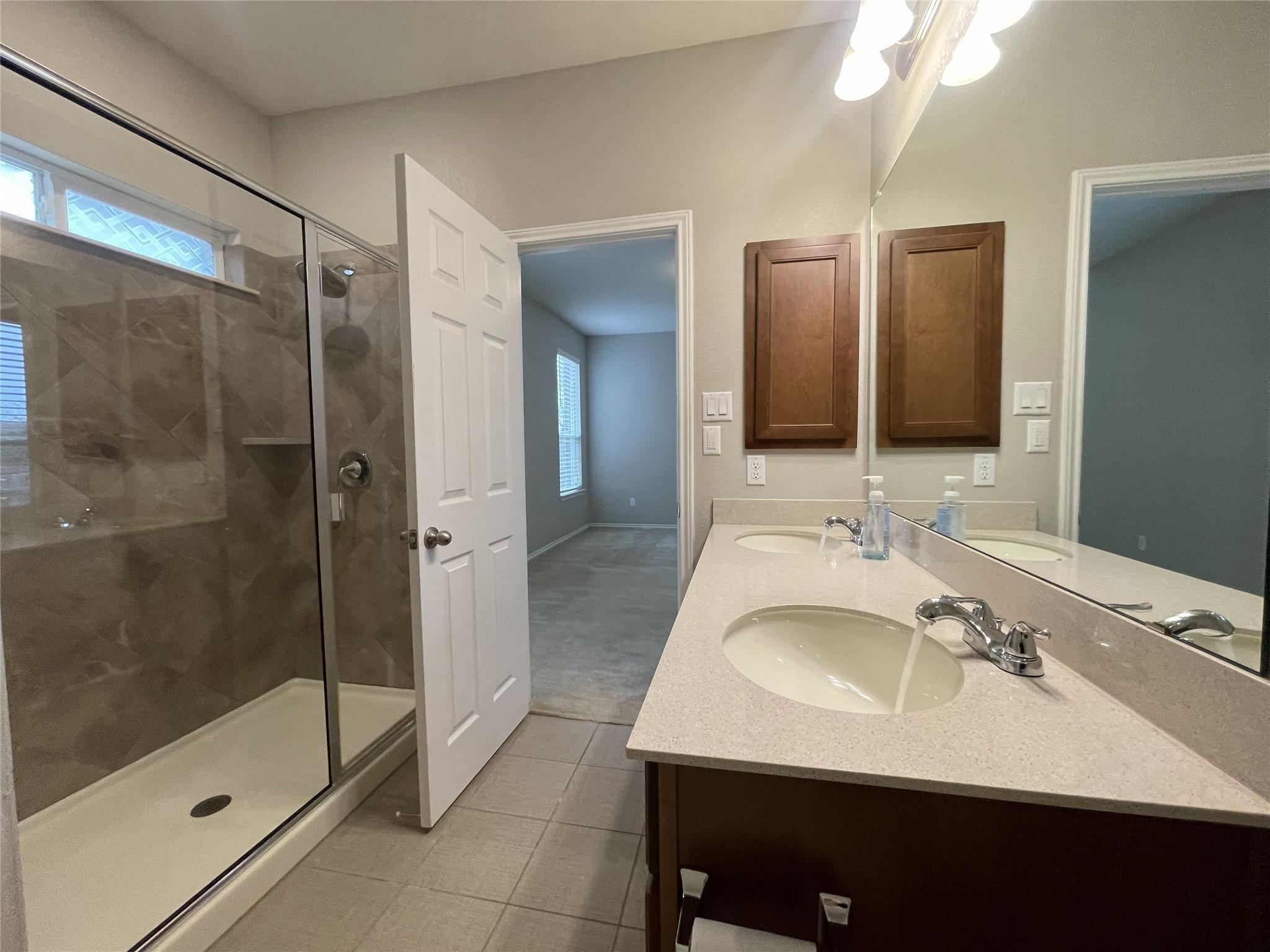 2471 Sunrise Road, Unit 62 Round Rock, TX 78664 - Photo 15 of 28 Full bath with double vanity, a stall shower, light tile patterned flooring, and light carpet