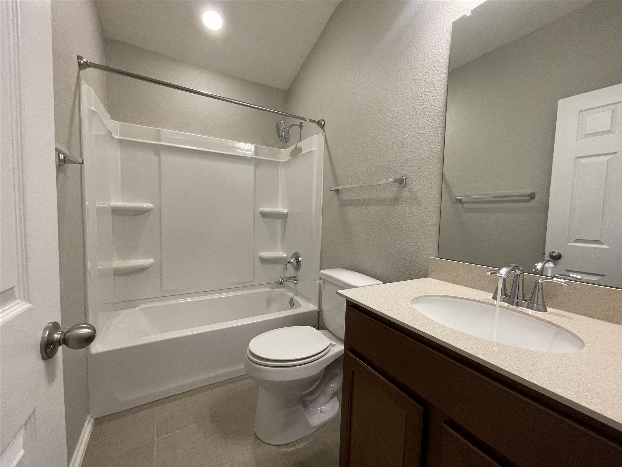 2471 Sunrise Road, Unit 62 Round Rock, TX 78664 - Photo 18 of 28 Full bathroom with a textured wall, vanity, bathtub / shower combination, and light tile patterned floors