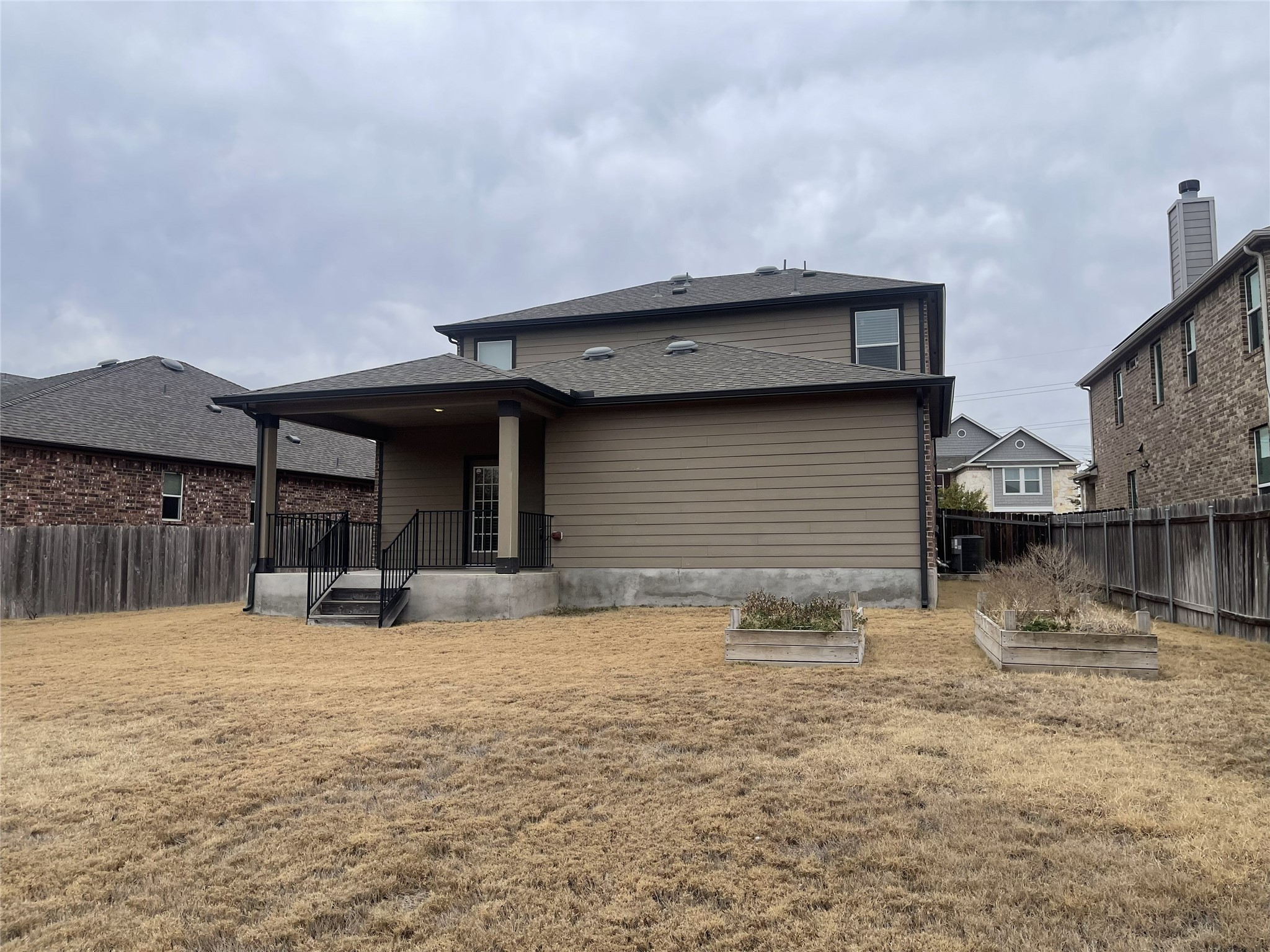 2471 Sunrise Road, Unit 62 Round Rock, TX 78664 - Photo 28 of 28 Rear view of house featuring a vegetable garden, a patio area, and a shingled roof