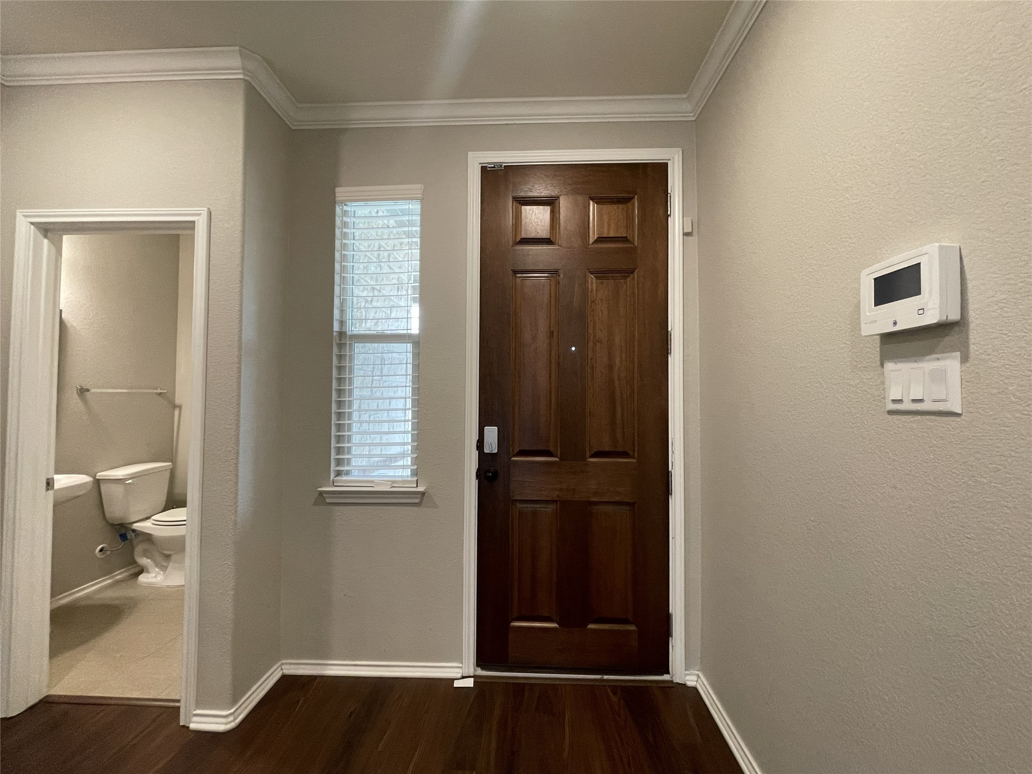 2471 Sunrise Road, Unit 62 Round Rock, TX 78664 - Photo 3 of 28 Foyer with a textured wall, dark wood-type flooring, and crown molding
