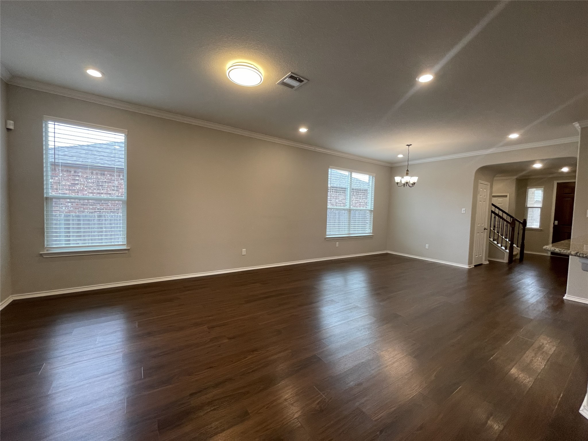 2471 Sunrise Road, Unit 62 Round Rock, TX 78664 - Photo 7 of 28 Unfurnished room featuring ornamental molding, dark wood finished floors, healthy amount of natural light, arched walkways, and hanging lights