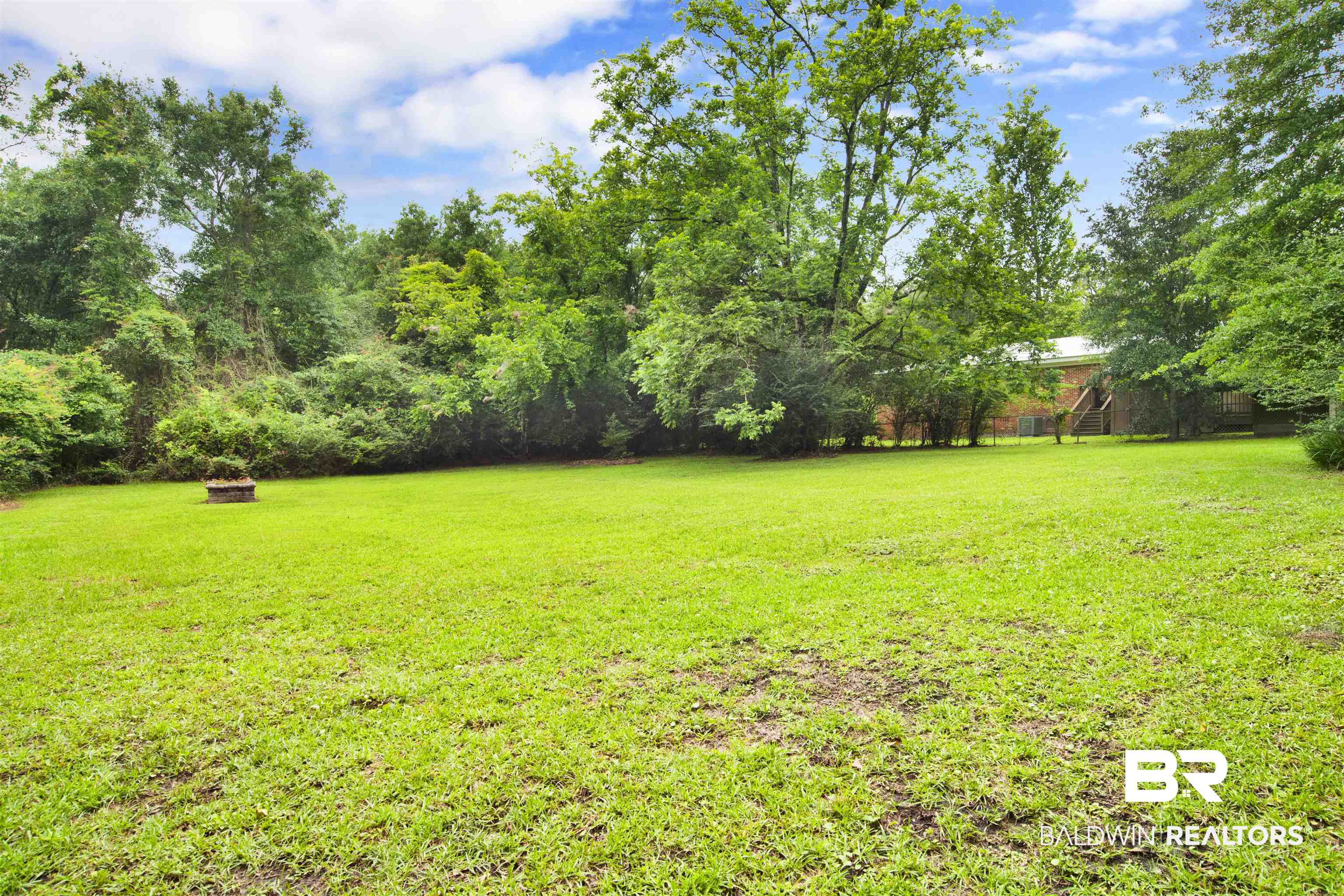 17714 Horseneck Road Bay Minette, AL 36507 - Photo 29 of 36 Expansive green lawn surrounded by mature trees, featuring a visible fire pit