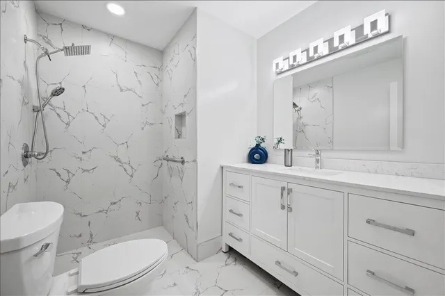 a bathroom with a sink a toilet and shower