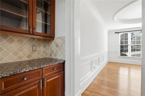 a view of an empty room with wooden floor fireplace and a window