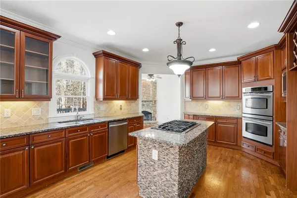 a view of a livingroom with wooden floor staircase and a kitchen