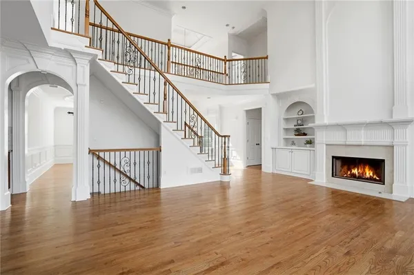 an empty room with a chandelier fan and windows