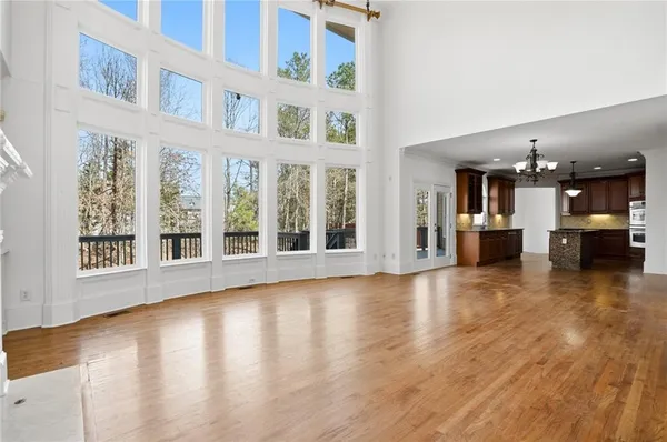 an empty room with wooden floor cabinet and windows