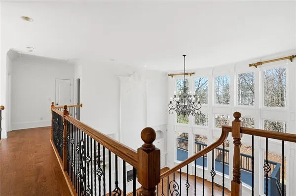 an empty room with wooden floor cabinet and windows