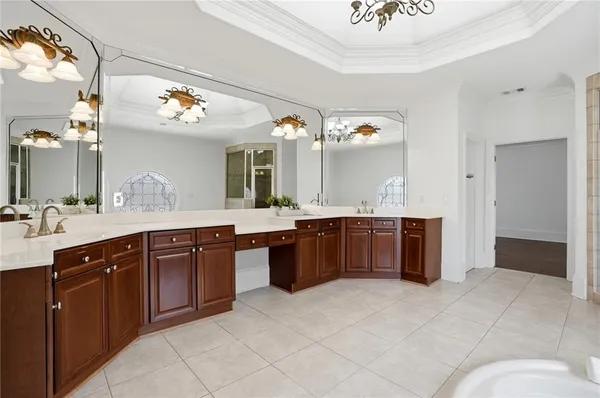 an empty room with a chandelier fan and windows