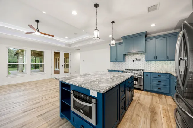 a kitchen with a stove and a wooden floor