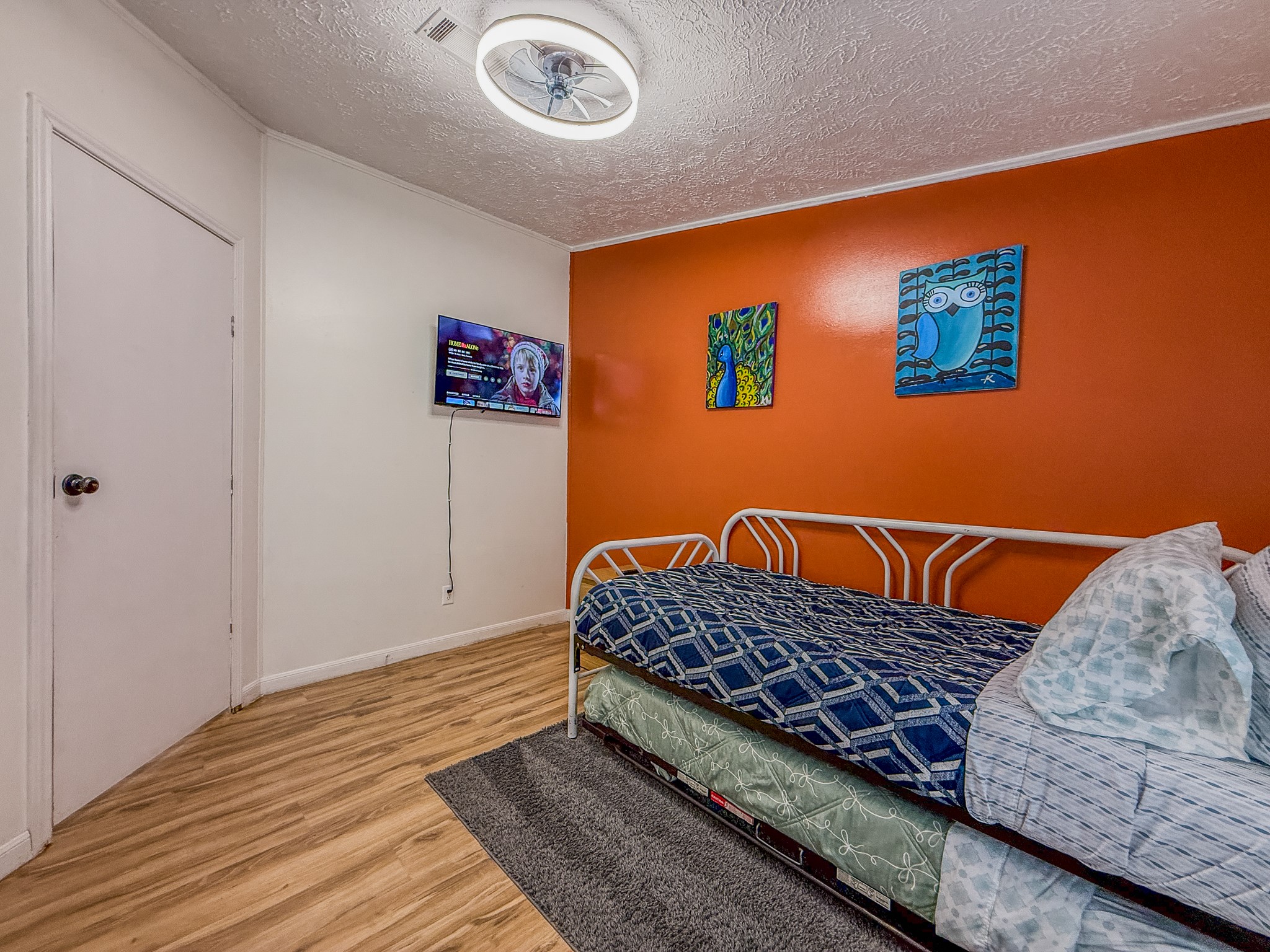 2015 Holly Street Austin, TX 78702 - Photo 18 of 24 A vibrant accent wall energizes this cozy sleeping quarter, featuring practical wood-look flooring.