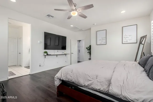 a bedroom with a large bed a flat tv screen and large closet