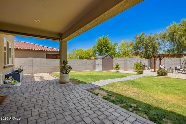 a view of a house with backyard and sitting area