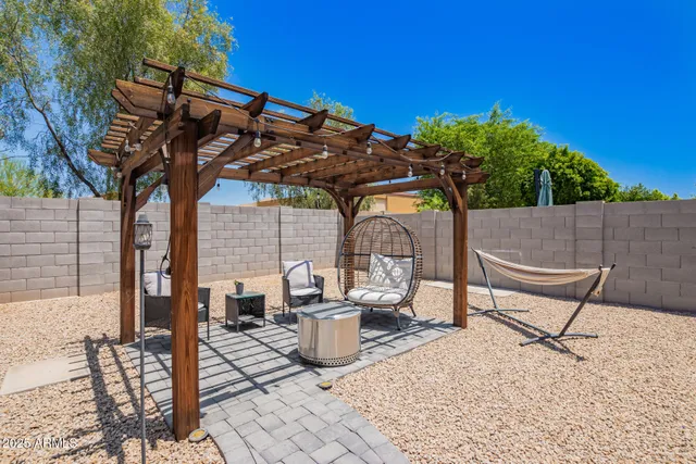 a patio table and chairs with potted plants