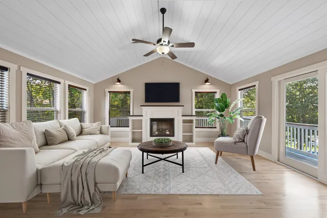 a living room with furniture ceiling fan and a window