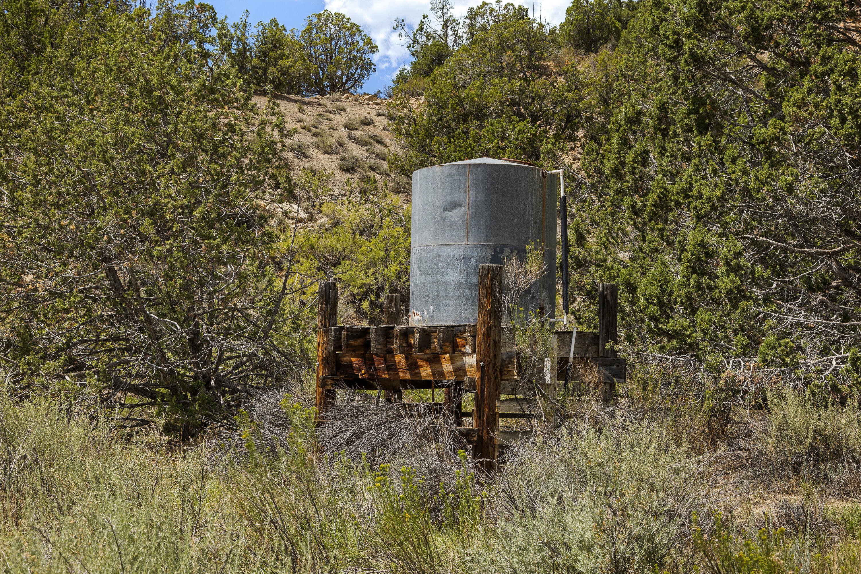 Rusty Nail Ranch Mount Carmel, UT 84755 - Photo 10 of 25 Gravity-fed galvanized storage tank on timber stand, part of the ranch's developed water system. Water Right No. 81-1776 conveys