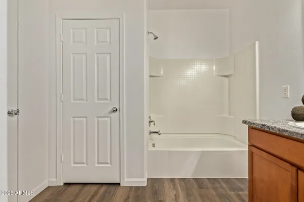 a bathroom with a granite countertop sink and a bathtub