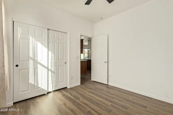 a view of an empty room with wooden floor and entryway
