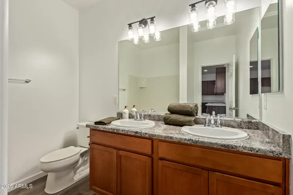 a bathroom with a granite countertop toilet sink and mirror