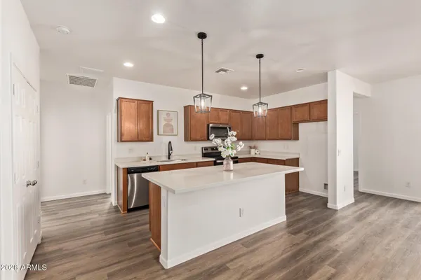 a kitchen with a sink a counter top space a stove and wooden floor