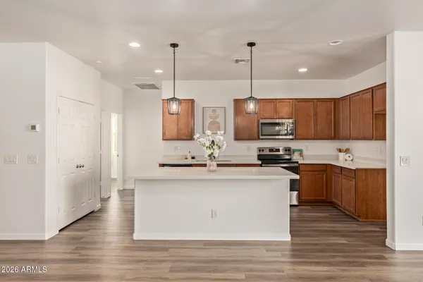 a kitchen with stainless steel appliances granite countertop a sink a stove and a wooden floors