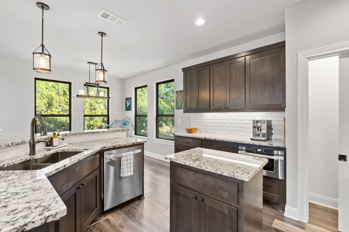 418 Summit Ridge Drive North Lago Vista, TX 78645 - Photo 12 of 40 a kitchen with granite countertop stainless steel appliances a sink stove and cabinets