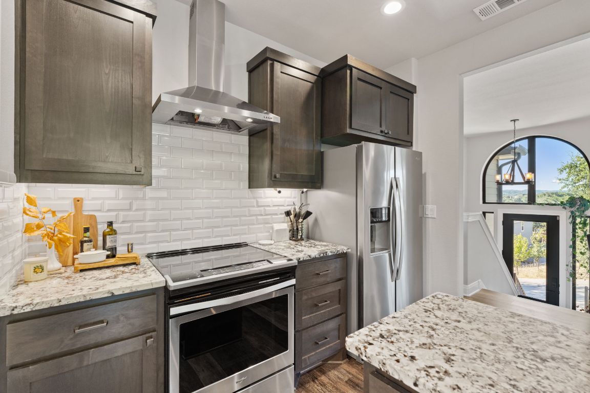 418 Summit Ridge Drive North Lago Vista, TX 78645 - Photo 13 of 40 a kitchen with stainless steel appliances granite countertop a refrigerator stove and sink