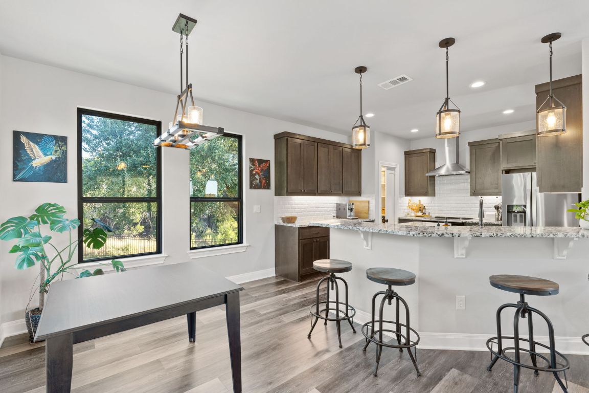 418 Summit Ridge Drive North Lago Vista, TX 78645 - Photo 15 of 40 a kitchen with stainless steel appliances granite countertop sink stove and wooden floor
