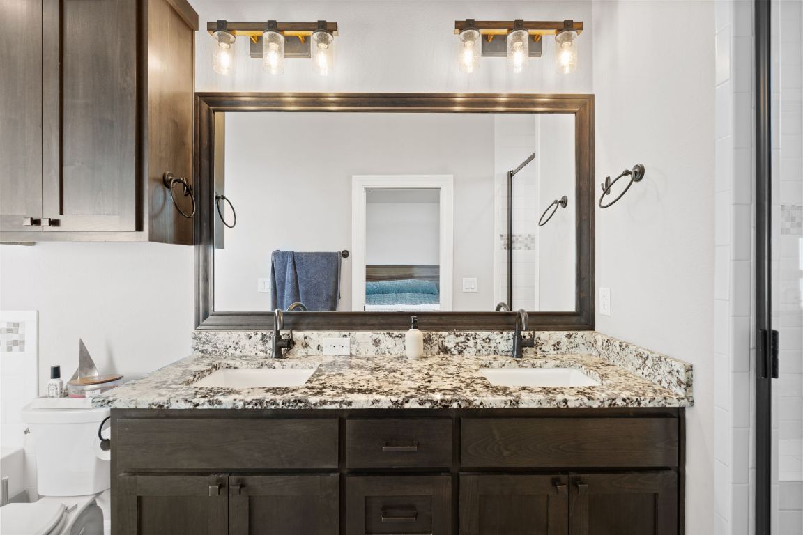 418 Summit Ridge Drive North Lago Vista, TX 78645 - Photo 27 of 40 a bathroom with a granite countertop sink and a mirror