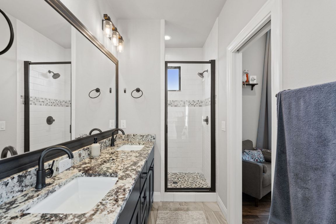 418 Summit Ridge Drive North Lago Vista, TX 78645 - Photo 29 of 40 a bathroom with a granite countertop shower sink and mirror