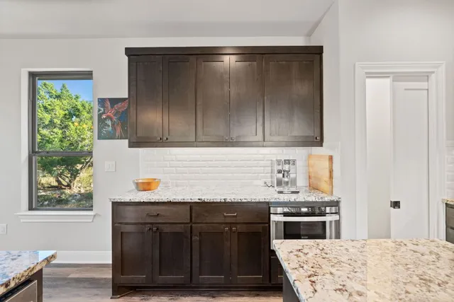a kitchen with a stove and wooden floor
