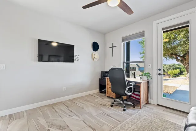 a view of a workspace with furniture and a window