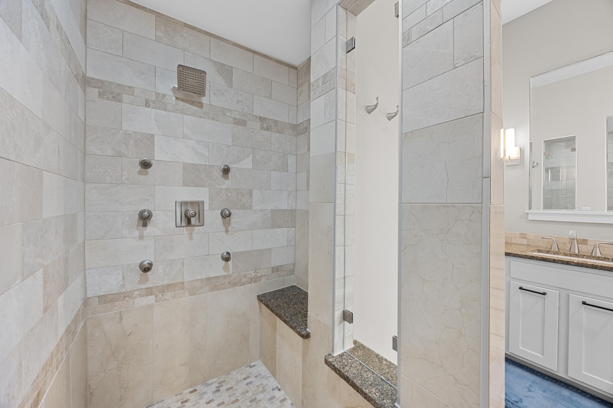 3907 Becker Avenue Austin, TX 78751 - Photo 19 of 37 Walk-in shower with marble tile, multiple heads, glass panel and vanity.
