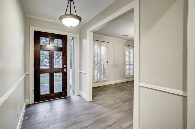 11426 Cold Spring Drive Houston, TX 77043 - Photo 4 of 7 a view of a hallway with wooden floor and windows